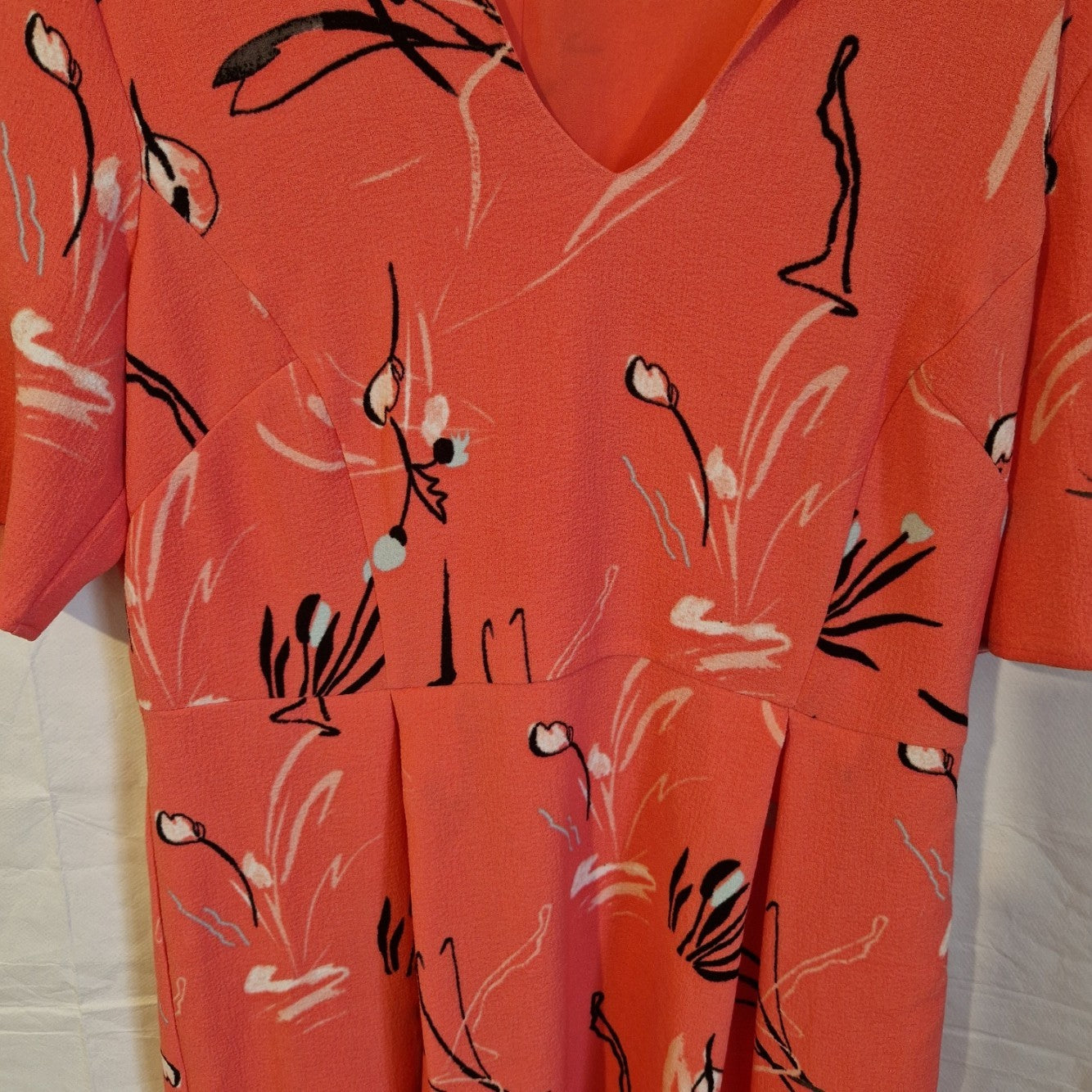 A pink floral fit and flare dress from Marks and Spencer with a V-neck and short sleeves.