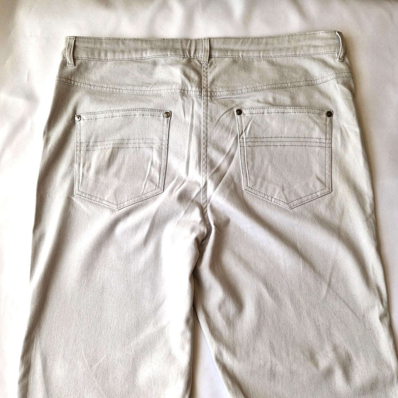 Back view of beige Emreco straight leg corduroy trousers featuring two back pockets.