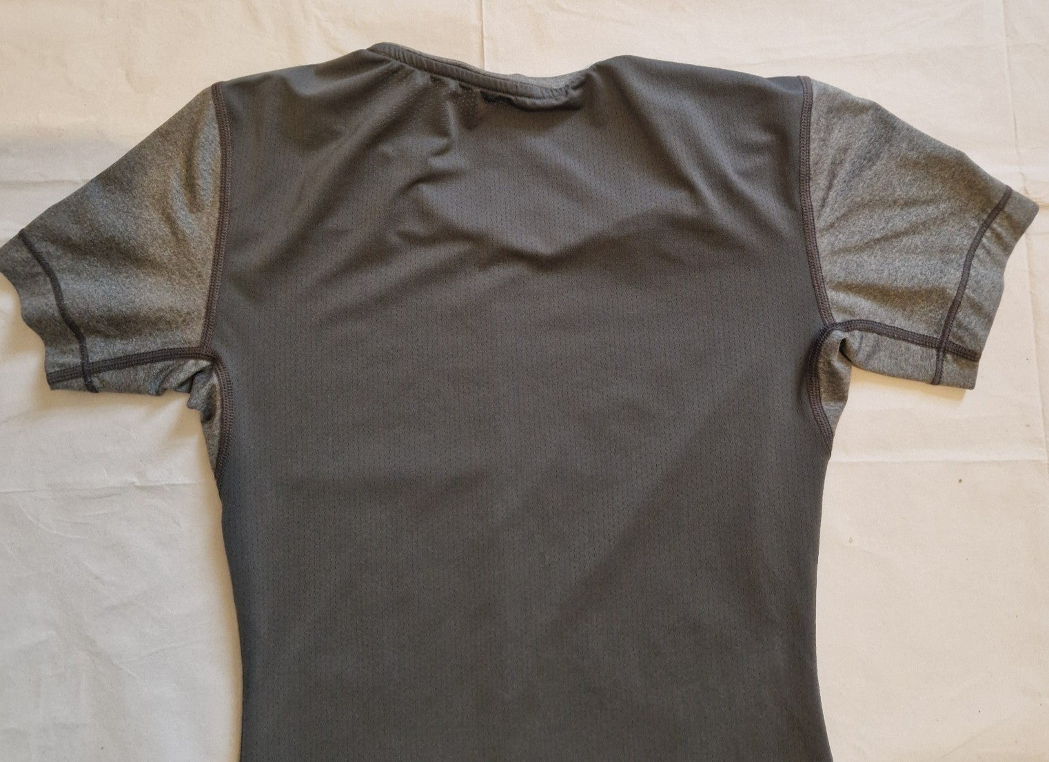 A grey Nike women's Dri-FIT running t-shirt with a slim fit and crew neckline.
