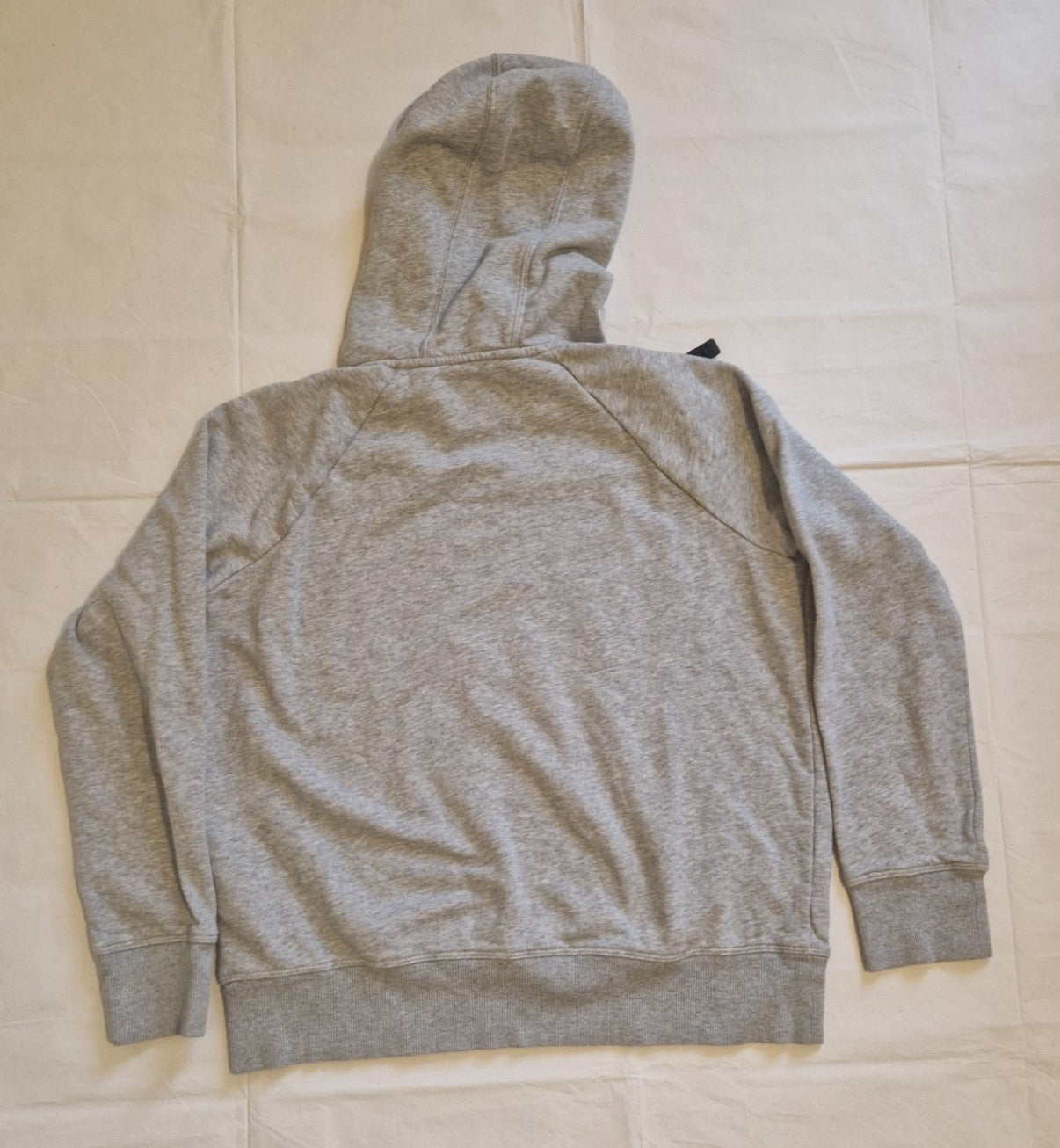 Back view of a grey Under Armour boys pullover hoodie made from a cotton fleece blend.