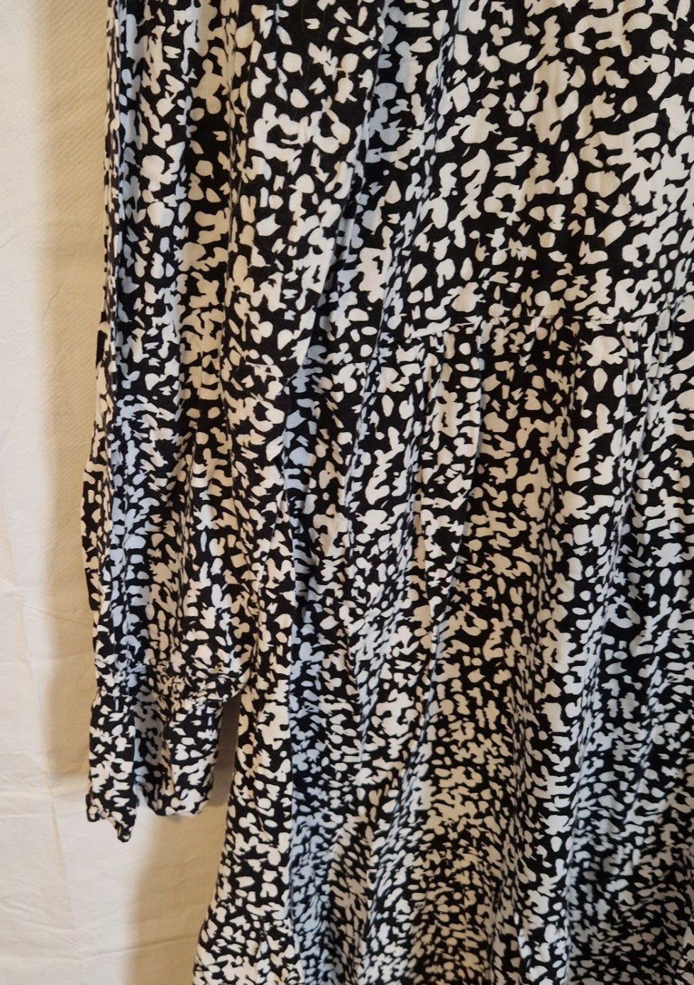 A black and white floral print midi dress with long puff sleeves and a ruffled hem.