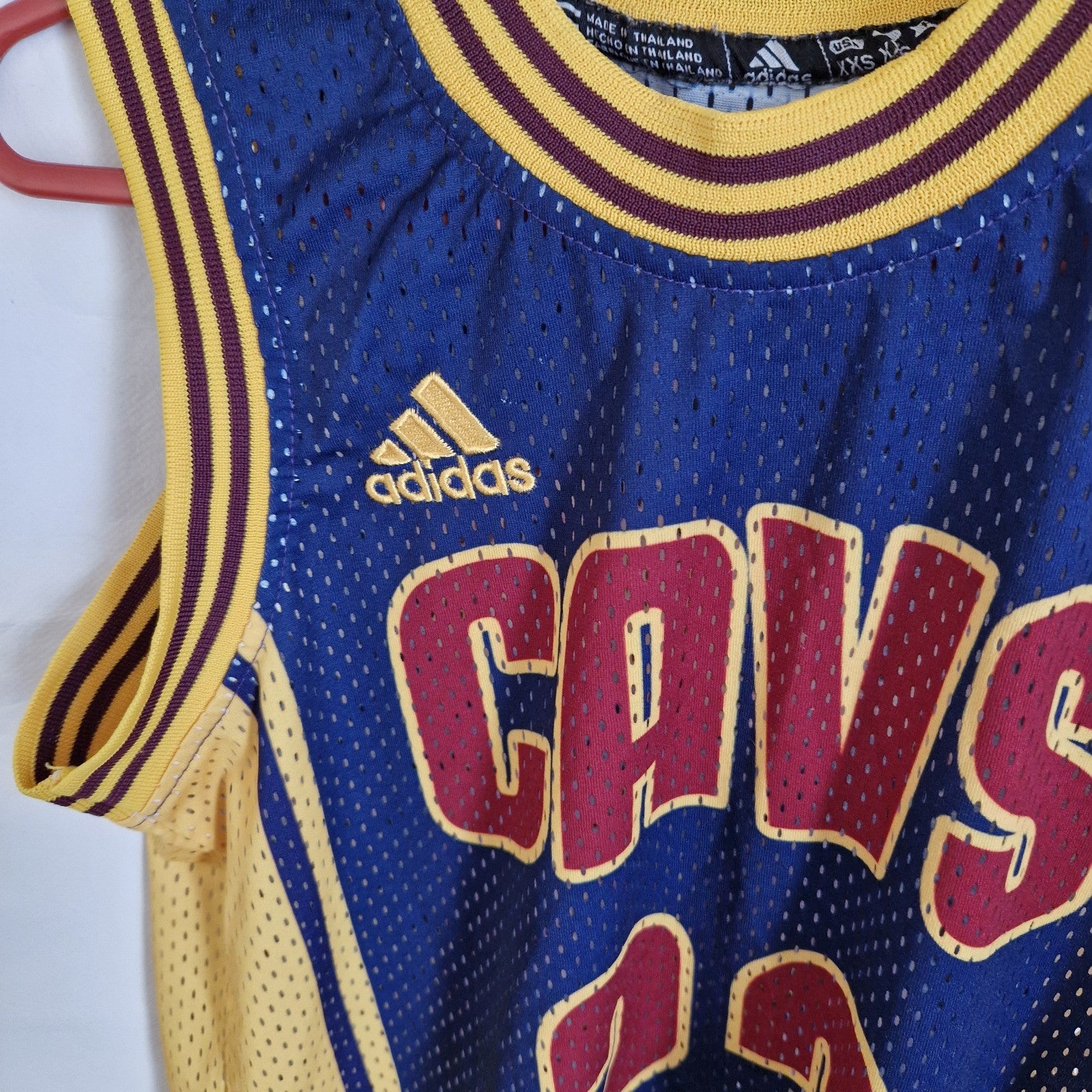 A blue and yellow Adidas Cleveland Cavaliers LeBron James basketball jersey in size XXS.