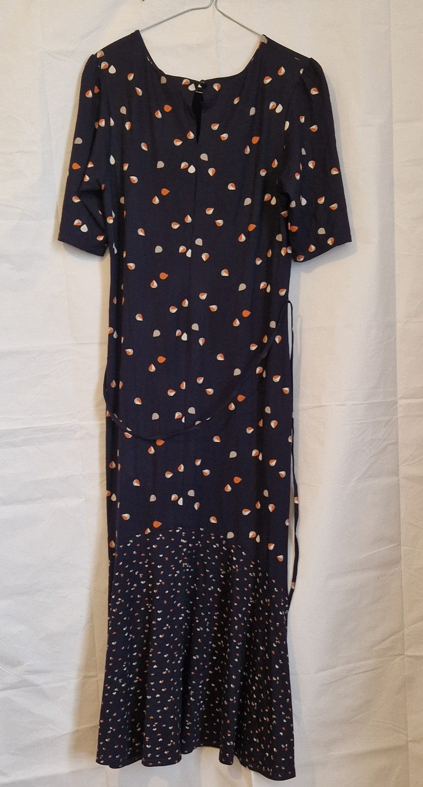 A navy blue fit and flare dress with a multicoloured floral print and a ruffle hem.