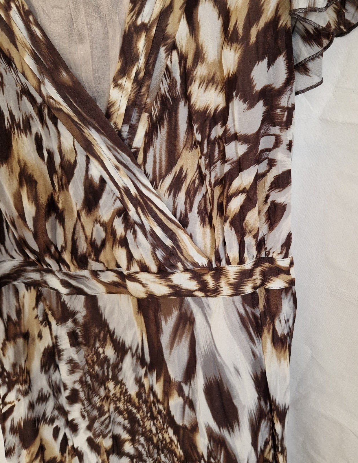 A brown and beige animal print chiffon maxi dress featuring a wrap-style bodice and ruffle sleeves.