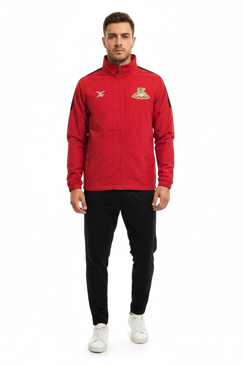 A man wears a red FBT Doncaster Rovers football training zip-up jacket with black accents.