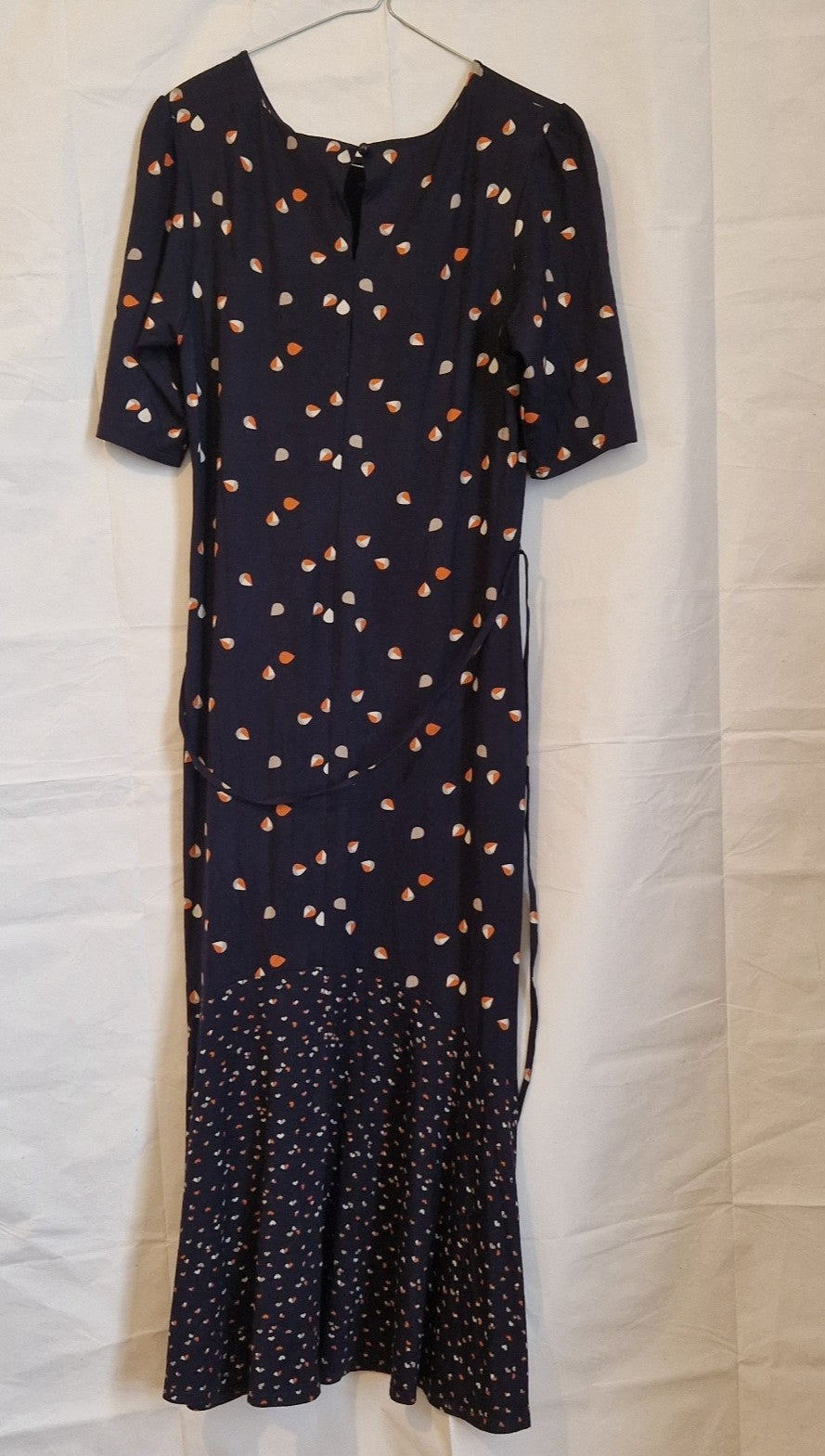 A navy blue fit and flare dress with a multicoloured floral print and a ruffled hem.