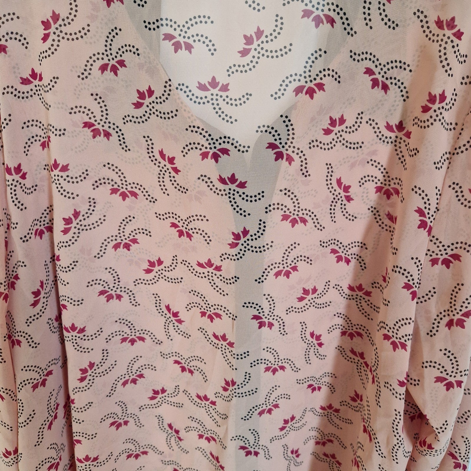 A light pink chiffon blouse featuring a repeating pattern of dark purple floral motifs and dots.