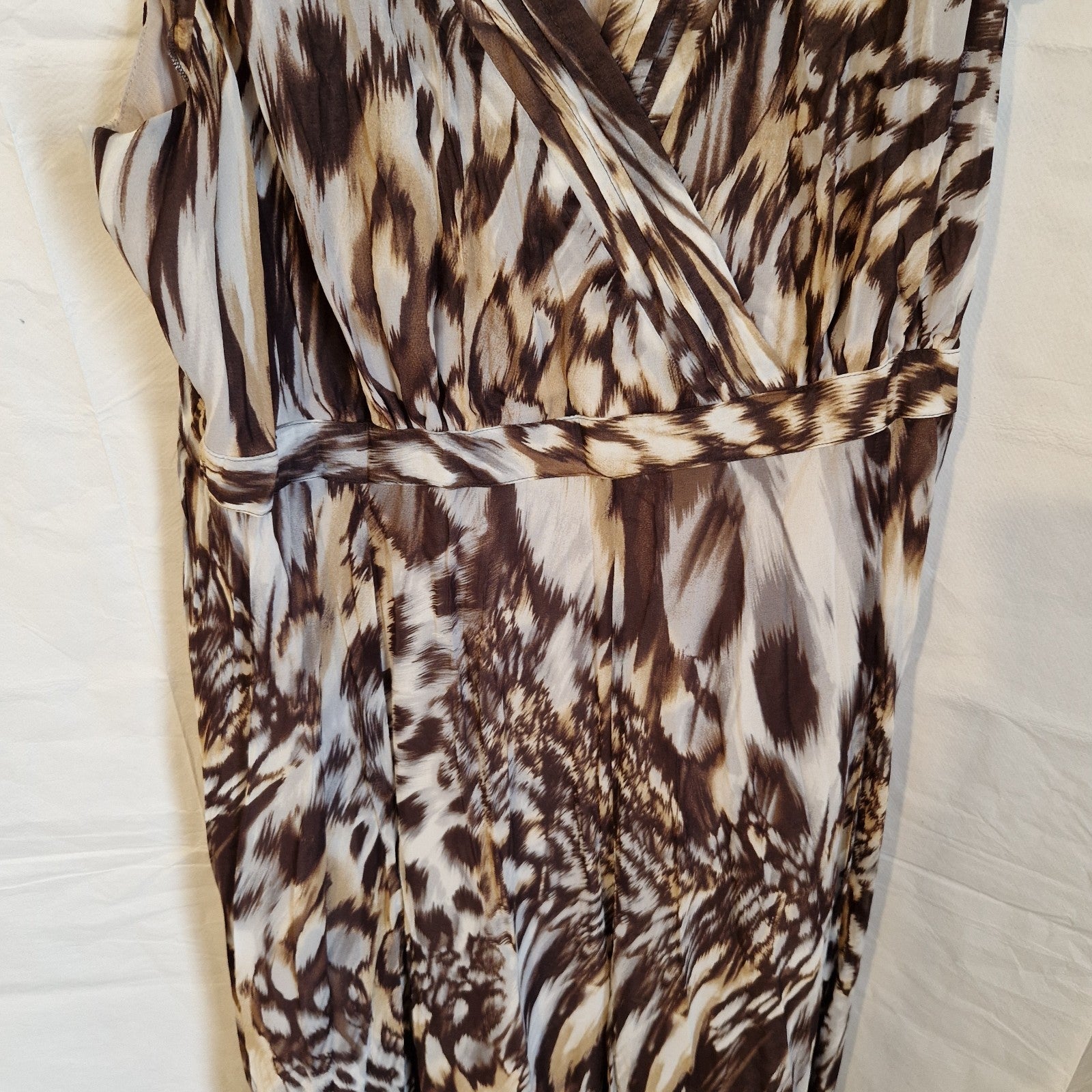 A brown and beige animal print chiffon maxi dress with a wrap-style bodice and waist detail.