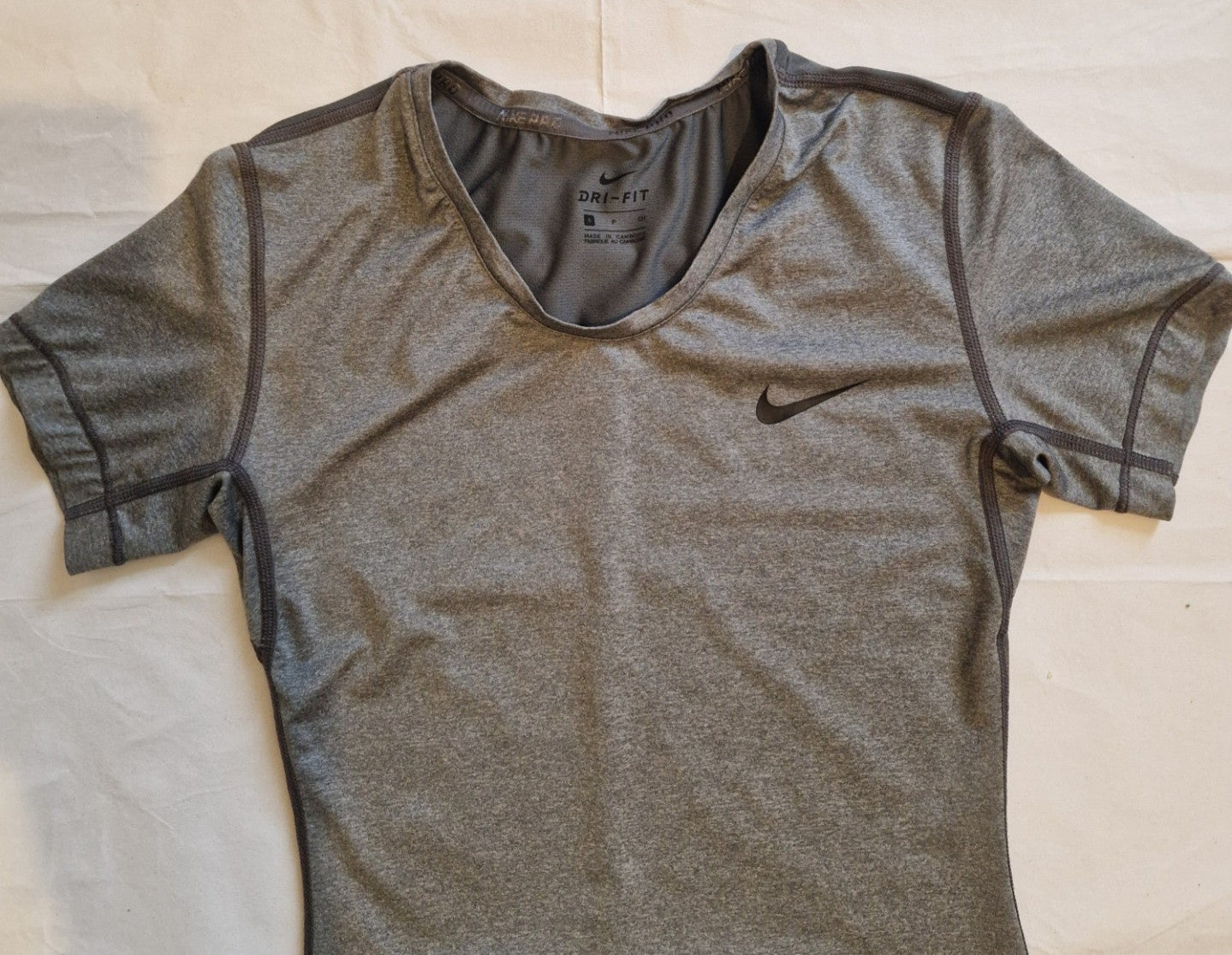 A grey Nike women's Dri-FIT short-sleeve training t-shirt with a crew neckline.