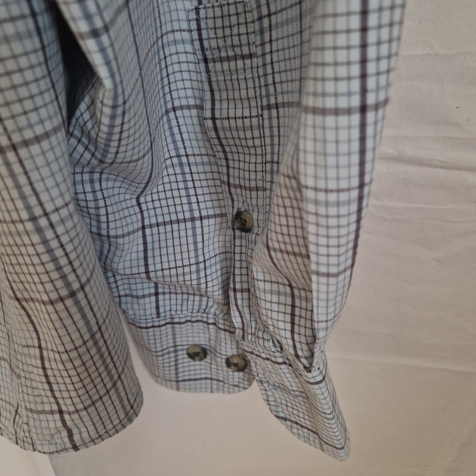 A long-sleeve Timberland shirt in a grey and blue check pattern with buttoned cuffs.