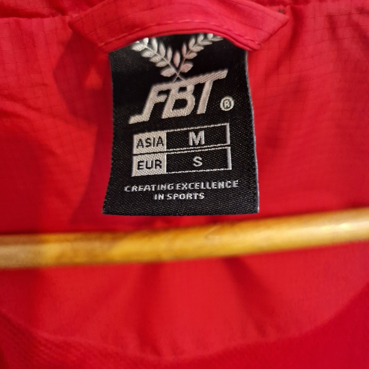 A red FBT Doncaster Rovers training jacket with a size tag showing Asia M and EUR S.