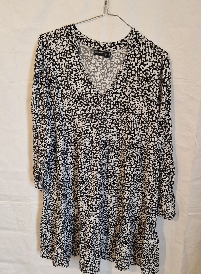 A black and white floral print midi dress with a V-neck and long sleeves.