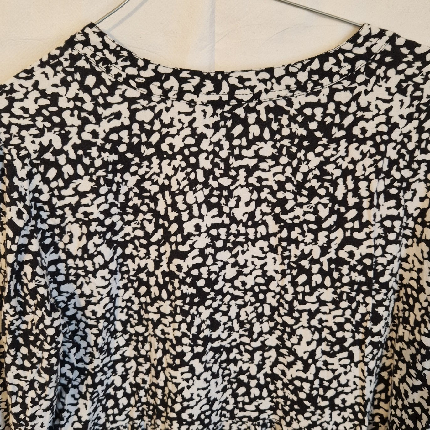 A black and white floral print midi dress with a V-neckline and long sleeves.
